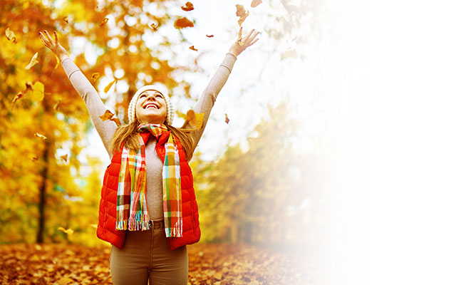 Woman tossing leaves into the air